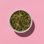 pumpkin-seeds-white-bowl-pink-background-with-shadows-minimalist-healthy-snack-photography_94064-45061